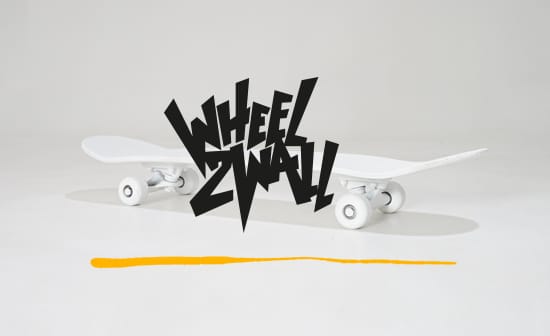 schwarzer Wheel2Wall Schriftzug vor weißem Skateboard, unterstrichen von gelben Strich.