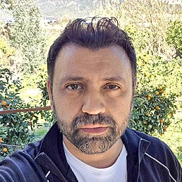 Portrait von Ersin Keser, Mitarbeiter von Knorke Media. Er trägt ein weißes Shirt mit dunkelblauer Jacke.